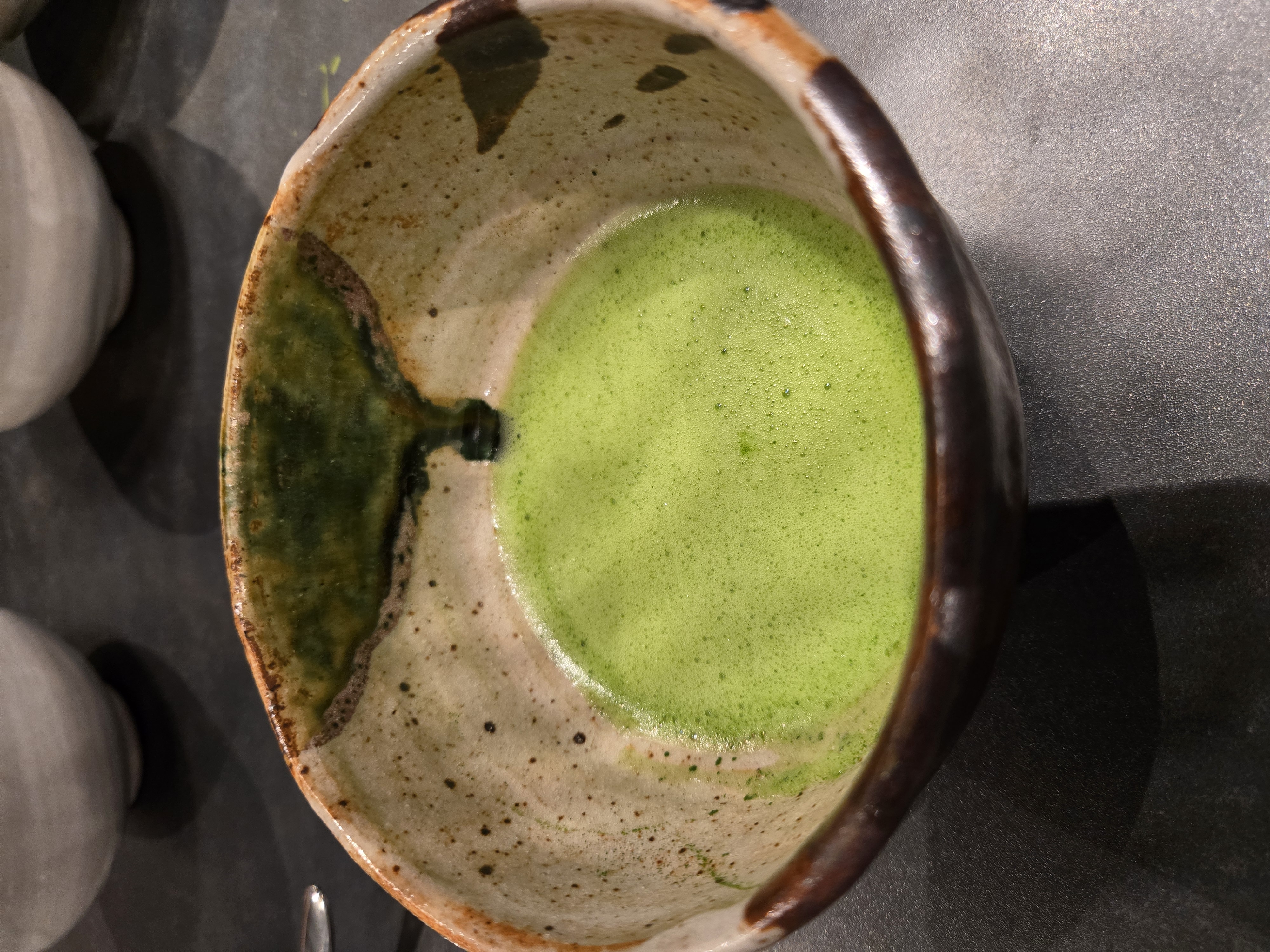 Bol de matcha fouetté avec un chasen en bambou, l'or vert du Japon
